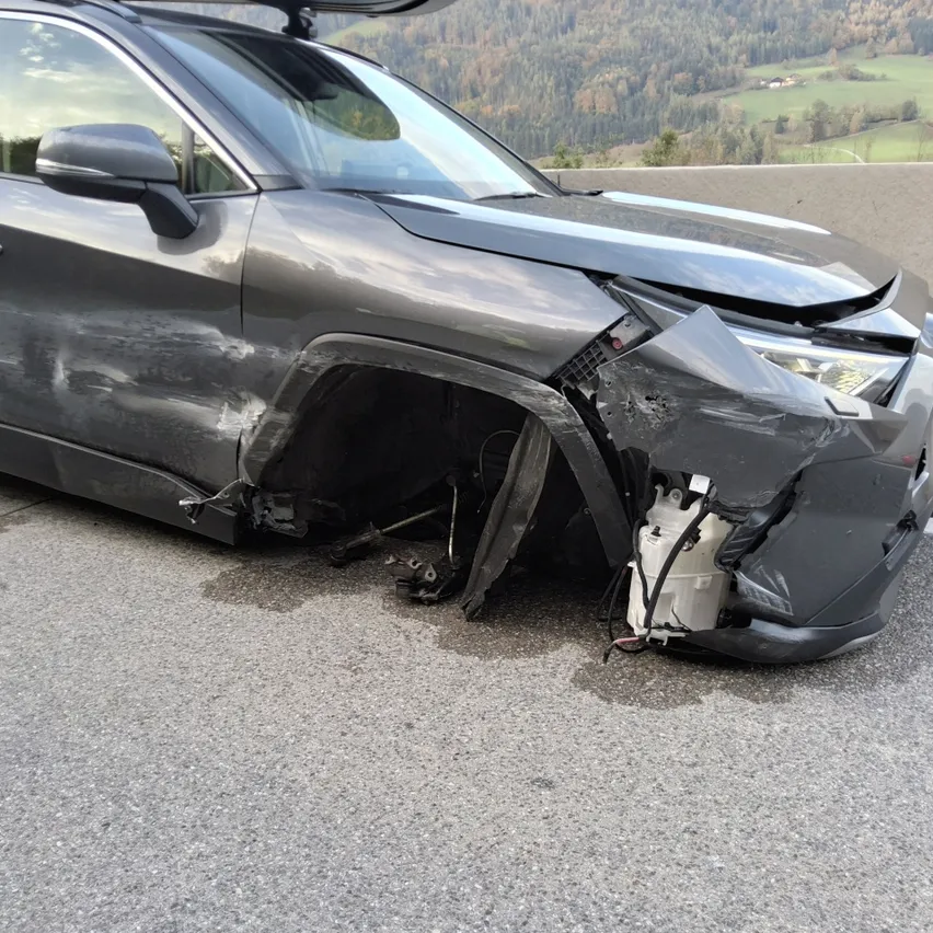 Ein schwarzer SUV war in einen Autounfall verwickelt, wobei der vordere Stoßfänger und die Motorhaube erhebliche Schäden erlitten.