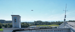 Eine Feuerwehrstation mit dem Namen FF - Hafnerbach Markt. Mehrere Feuerwehrfahrzeuge sind davor geparkt. Der Himmel ist klar und blau.