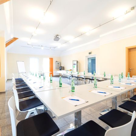 Bild enthält, Indoors, Meeting Room, Office, Room, Pen, Chair, Furniture, Table, Tabletop, Interior Design