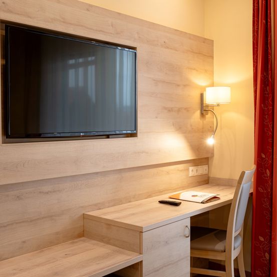 Bild enthält, Indoors, Interior Design, Wood Panels, Screen, Computer Hardware, Monitor, Chair, Wood, Table, TV