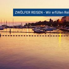 Ein Hafen mit vielen verankerten Booten unter einem Sonnenuntergangshimmel. Das Wasser ist ruhig mit einem Spiegelbild des Himmels. Ein blaues Banner mit der Aufschrift Zwolfer Reisen - Wir erfullen Rei.