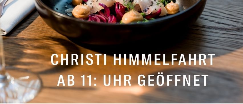 Eine Schüssel mit Meeresfrüchtesalat auf einem Holztisch mit einem Weinglas, ab 11 Uhr geöffnet.