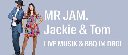 A man and a woman dressed in vibrant colors are standing close to each other, smiling for a photo. The text reads 'MR JAM. Jackie & Tom LIVE MUSIK & BBQ IM DR0I'.