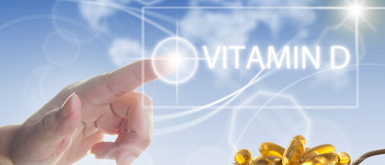 Eine Hand zeigt auf ein leuchtendes Symbol mit der Aufschrift 'VITAMIN' über einem blauen Hintergrund. Unten hält ein Löffel mehrere goldene Pillen.