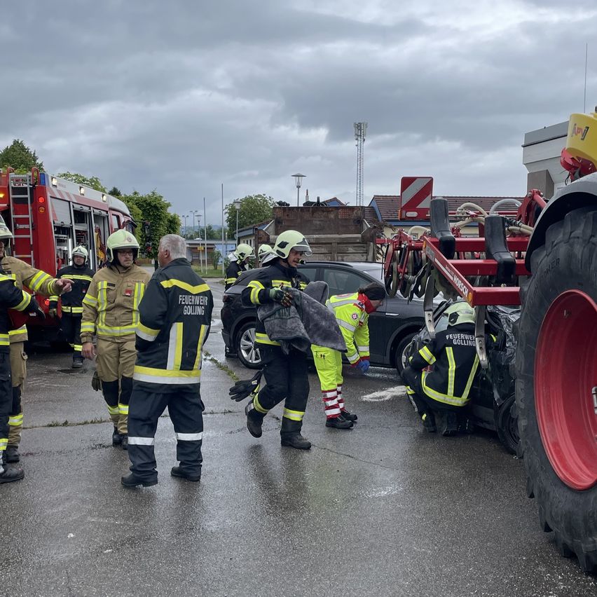 Firefighters are attending to a car accident, one person is being carried out of the vehicle.