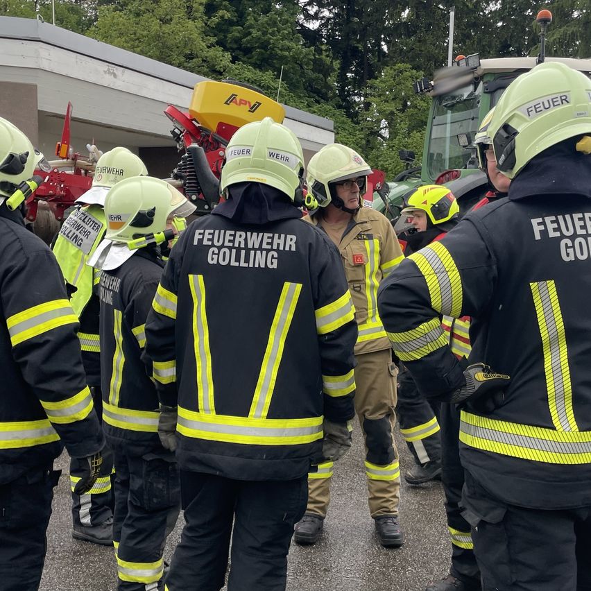 A group of firefighters from Gollling stand in formation. The team is led by an officer in a tan uniform.