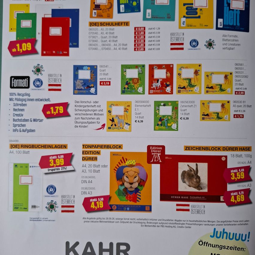 A promotional poster displays various educational materials with prices, including notebooks, drawing blocks, and paper blocks. The poster highlights discounts and special offers.