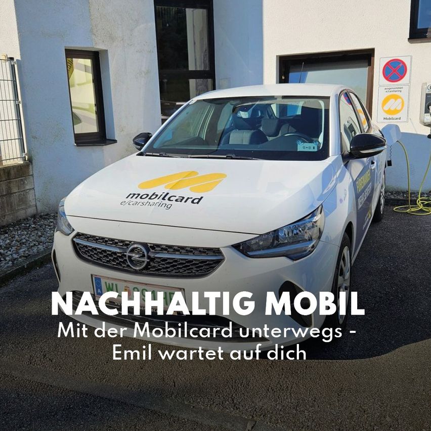 Ein weißer Wagen mit dem Text 'Nachhaltig mobil' steht vor einem Gebäude. Das Auto hat ein gelbes Logo und Text auf der Seite. Ein gelbes Ladekabel ist mit dem Auto verbunden.