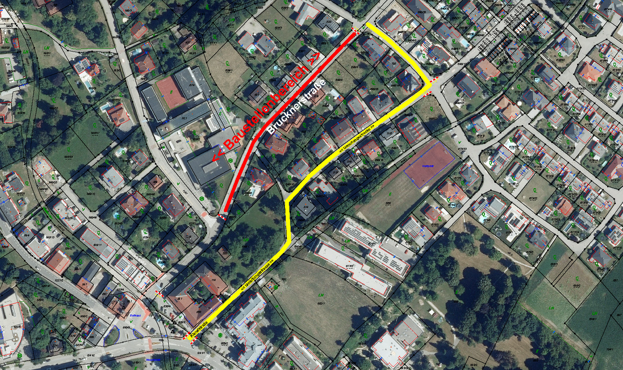 Aerial map showing a town with marked roads and buildings, including a red line indicating a road named Baustellenbereich and a yellow line indicating a road named Bruckenstrasse.