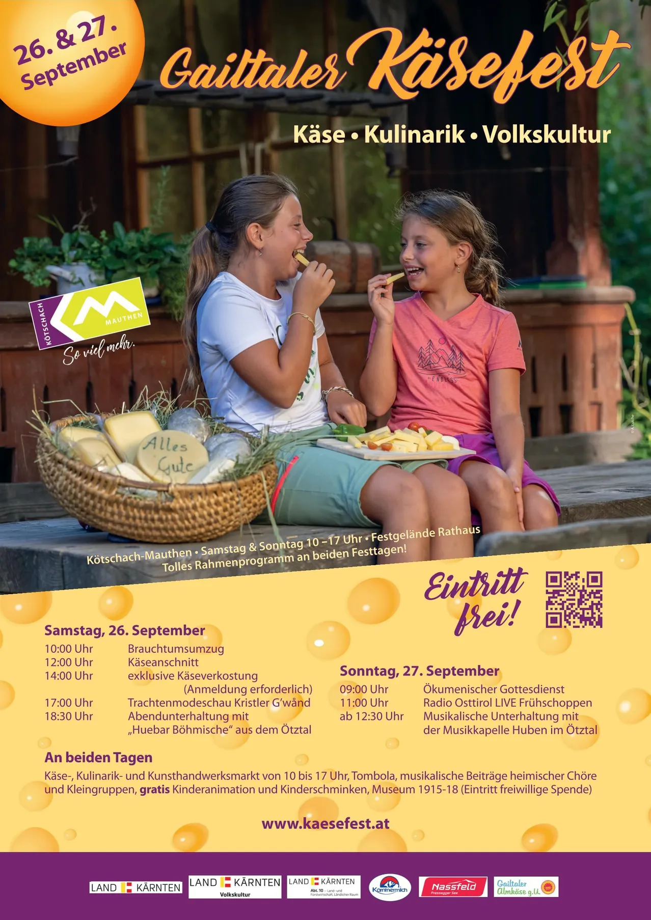Zwei Mädchen sitzen auf einer Bank, eine isst Käse und die andere isst ein Gemüse. Sie sind umgeben von einem Korb mit Käse und einem Teller mit Gemüse. Ein Plakat im Hintergrund bewirbt ein Käse- und Kulinarikfestival mit verschiedenen Aktivitäten.