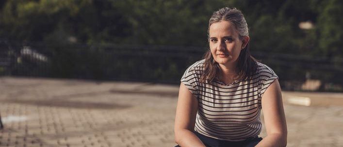 Eine Frau mit einer Taube auf einer Betonkante, trägt ein gestreiftes Shirt und Hose. Der Text lautet 'Fangst Elli Bauer' und 'Do. 26. Februar'.