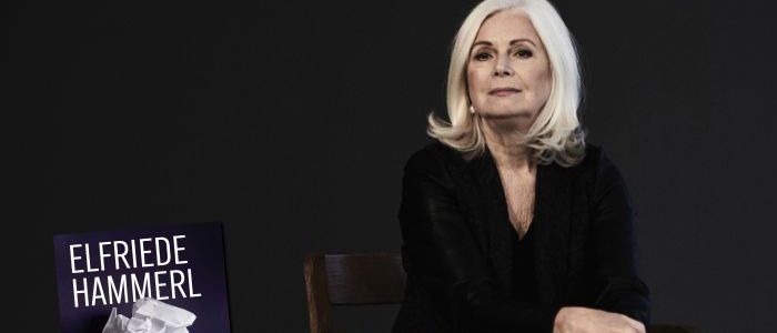 Ein Bild von Elfriede Hammerl, die in einem Holzstuhl sitzt und ein Buch mit dem Titel 'Gespräche, die ich nie geführt habe' in der Hand hält. Der Hintergrund ist schwarz mit Textüberlagerungen. Das Datum 'Do, 5. März 2026' ist sichtbar.