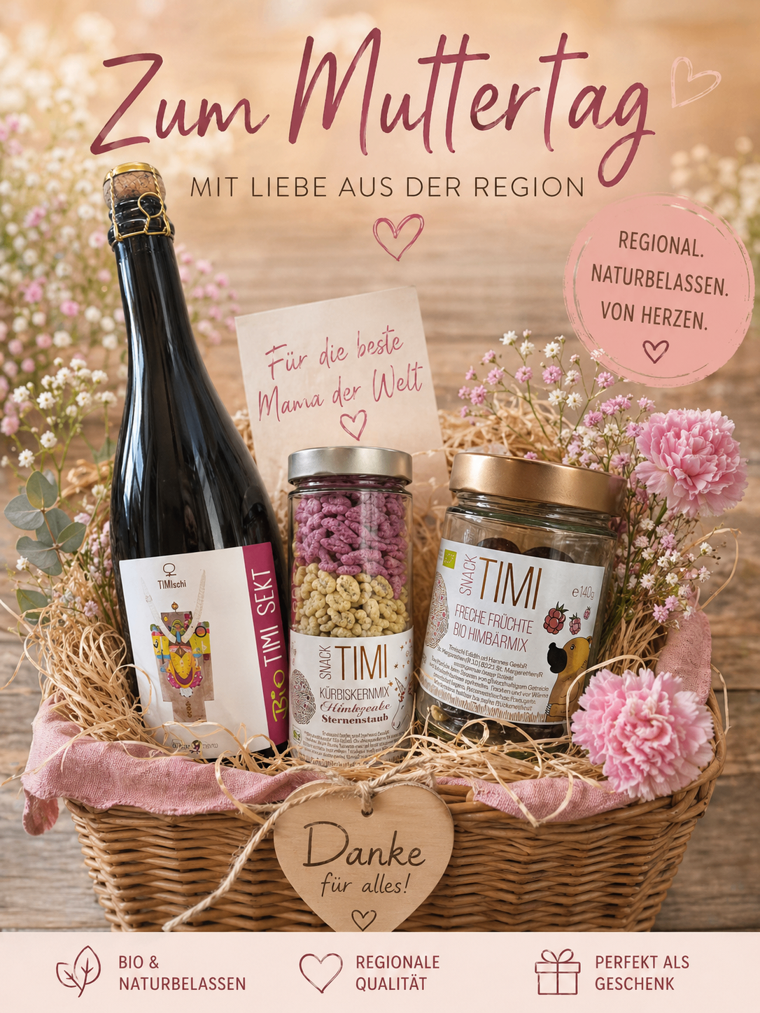 Ein Korb mit einer Flasche Wein, einer Dose Timi Snack-Mix und einer weiteren Dose mit der Aufschrift Timi mit einem Herz darüber. Ein Kärtchen mit der Aufschrift 'Für die beste Mama der Welt'. Text lautet 'Aus der Region mit Liebe' und 'Regional, naturgesegnet. Von Herzen.'