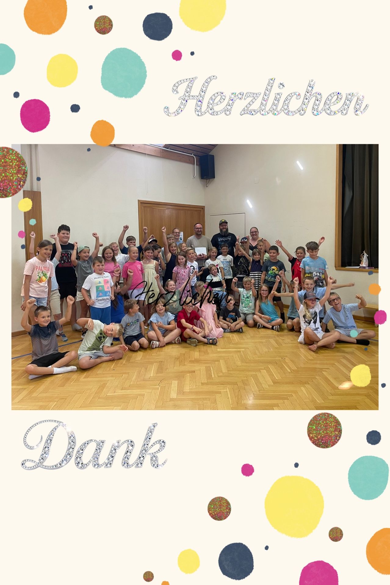 Eine Gruppe von Kindern und Erwachsenen posiert für ein Foto in einem Raum mit Holzböden, einige halten Urkunden. Der Raum hat eine weiße Wand, eine Holztür und einen Lautsprecher. Die Worte 'Herzlichen Dank' sind oben geschrieben.