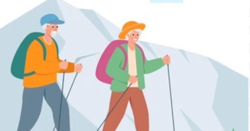 Two elderly people are hiking with backpacks and trekking poles in a mountainous area.