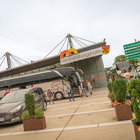 Bild enthält, Person, Road, Plant, Potted Plant, Car, Vehicle, Bus, Wheel, Shoe, Planter
