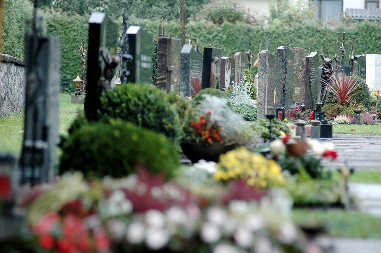 Ein Friedhof mit vielen Grabsteinen und Denkmälern. Eine Mischung aus Blumen und Pflanzen schmückt das Areal.