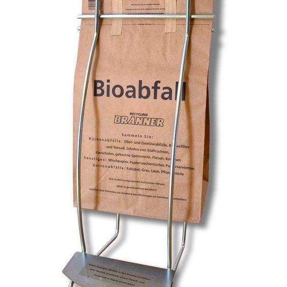 Ein Metallständer hält einen braunen Papiersack mit der Aufschrift Bioabfall Recycling Brandner. Er enthält Richtlinien zur Sammlung von Küchenabfällen und anderen Wertstoffen.