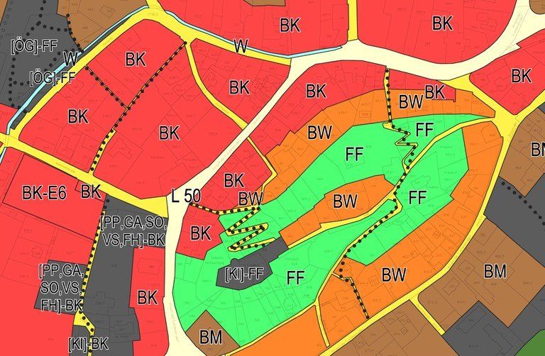 Das Bild zeigt eine Karte mit verschiedenen farbcodierten Bereichen und beschrifteten Abschnitten. Rote, gelbe und grüne Zonen sind mit Abkürzungen wie BK, BW und FF markiert. Ein zentraler Bereich ist grün hervorgehoben und mit mehreren Etiketten und einem gepunkteten Pfad versehen.