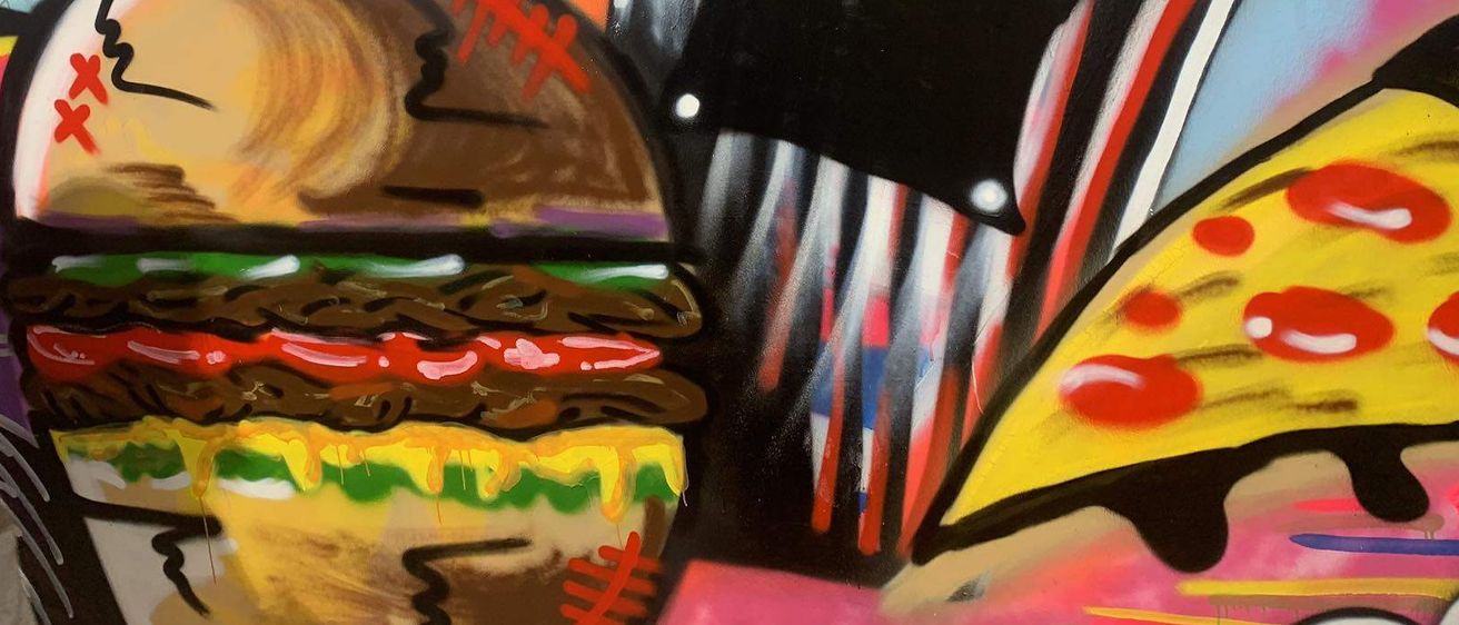 Ein farbenfrohes Wandbild zeigt einen großen Hamburger mit verschiedenen Belägen, neben einem stilisierten Mülleimer und Pommes.