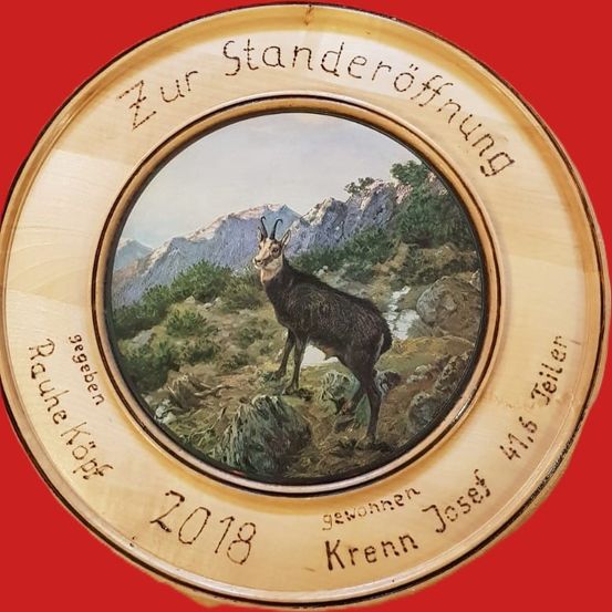 Eine hölzerne Platte zeigt eine Ziege in den Bergen mit dem Text 'Zur Standeroffnung'. Sie wurde Joseph Krenn am 416. Zeller geschenkt. Das Datum 2018 ist ebenfalls auf der Platte abgebildet.