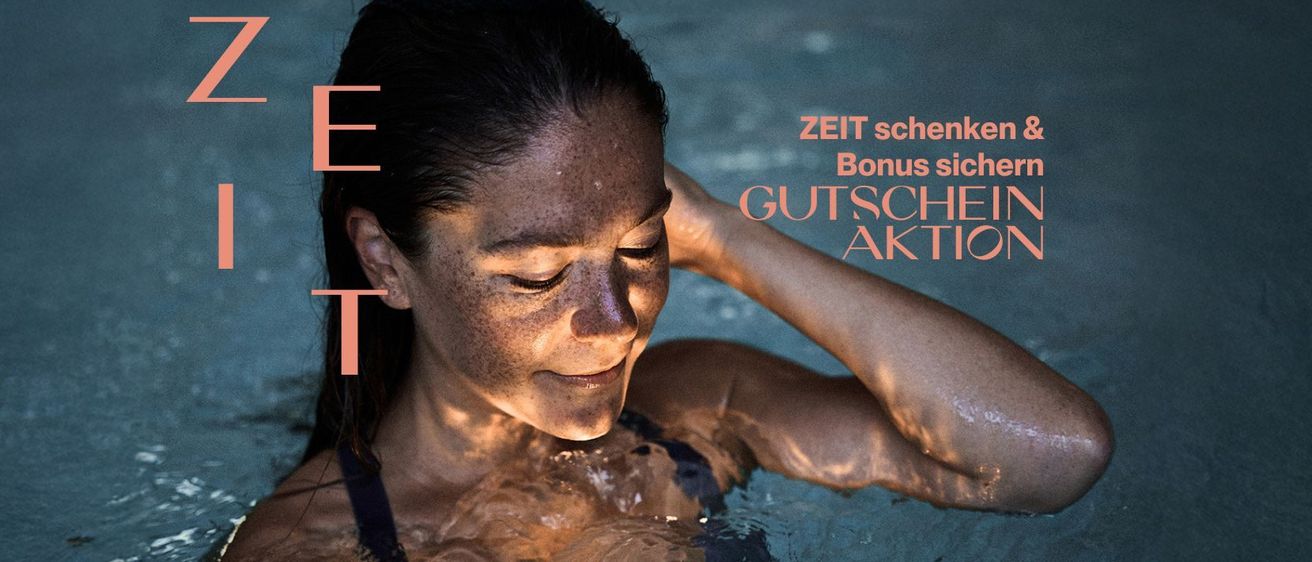 Eine Frau mit Sommersprossen lächelt und schaut nach unten, während sie ihren Kopf mit der rechten Hand hält, eingetaucht in einem Pool. Das Bild hat einen Wasserzeichen mit den Worten 'ZEiT scher Bonus GUTSCHEIN AKT'.