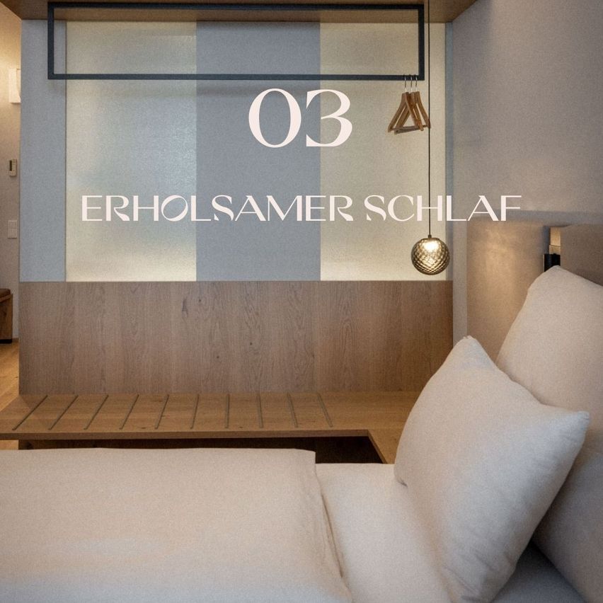 Ein ruhiges Schlafzimmer zeigt ein Bett mit weißen Kissen. Darunter steht '03 Erholsamer Schlaf' an der Wand. Eine Holzbank und eine Lampe verleihen dem Raum eine gemütliche Atmosphäre.