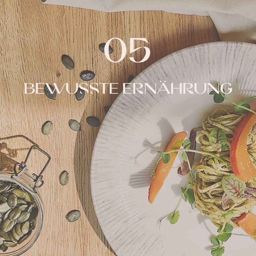 Ein weißer Teller auf einem Holztisch mit einem Gericht aus Nudeln, orange Karotten und grünen Blättern. Ein Glas mit Kürbiskernen ist in der Nähe. Der Text lautet '05 Bewusste Ernährung'.