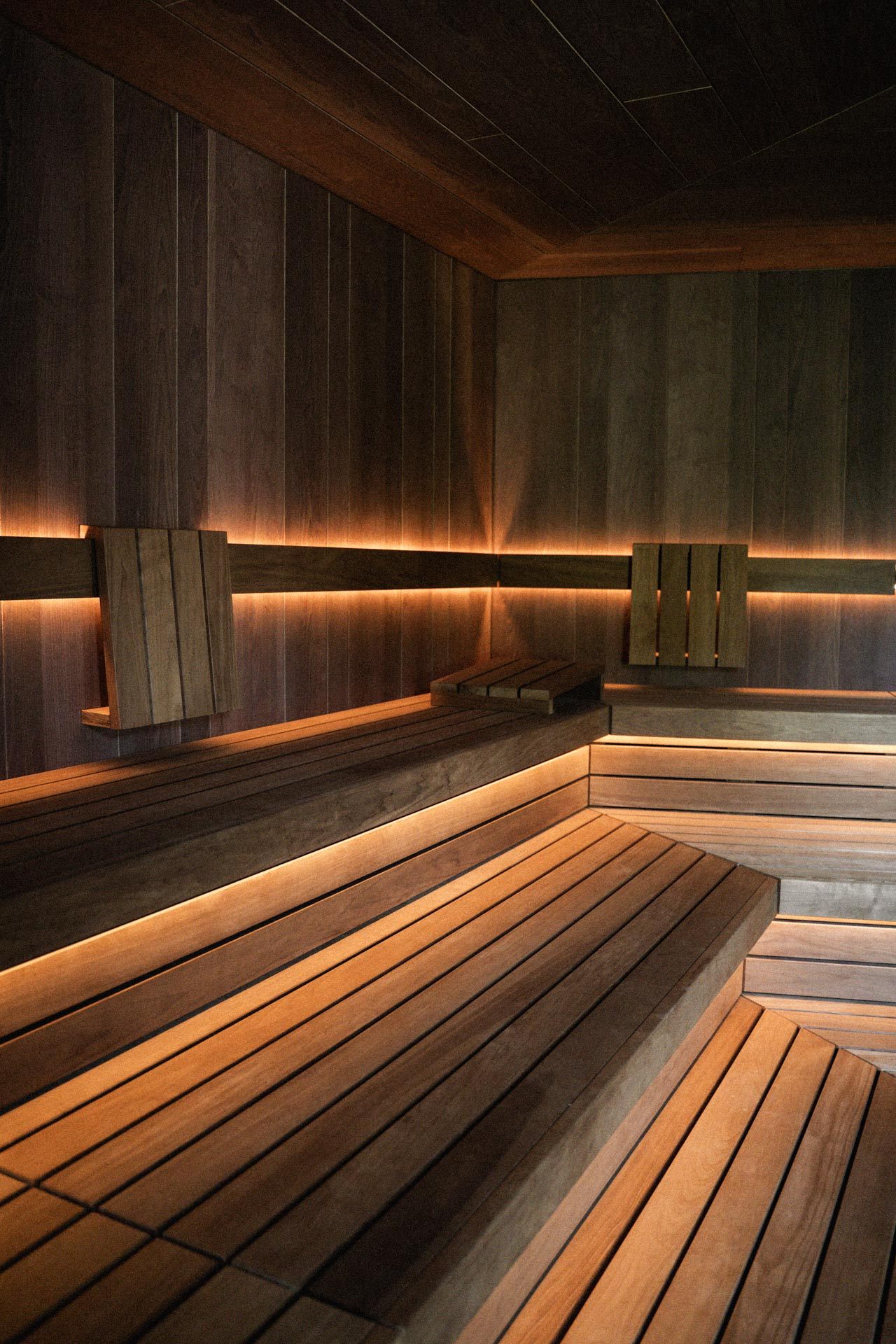 Sauna mit Holzverkleidung und indirekter Beleuchtung in mehreren Ebenen