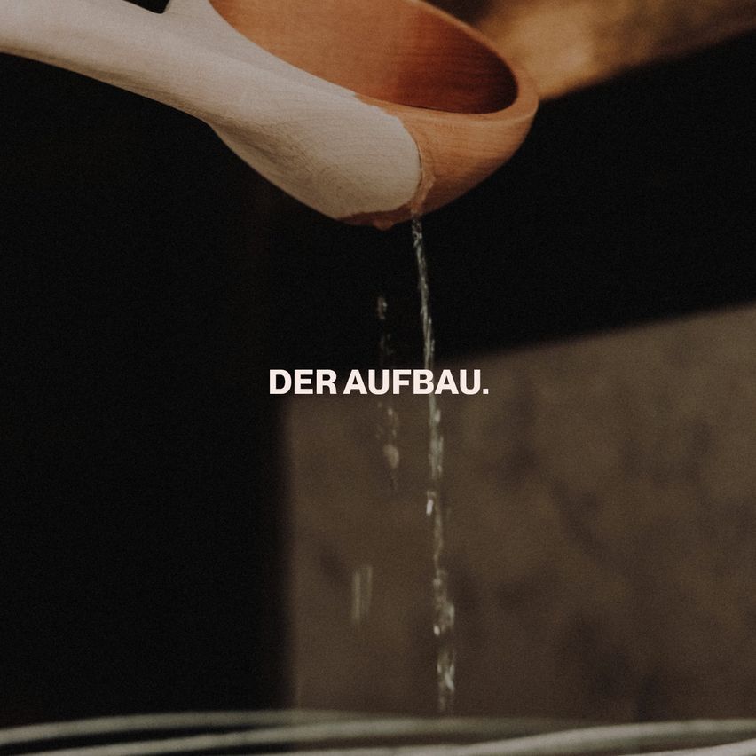 Ein hölzerner Löffel mit tropfendem Wasser, der Text 'Der Aufbau' ist unten rechts sichtbar.
