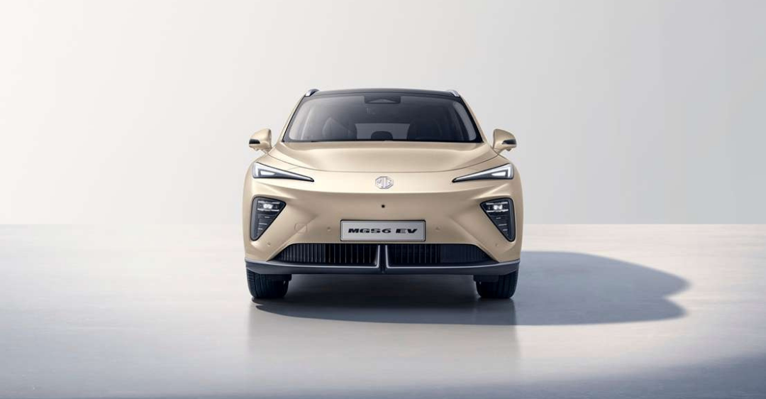 Die Vorderansicht eines beigefarbenen Elektroautos mit schlankem Design, LED-Scheinwerfern und MG-Logo auf der Kühlerhaube.