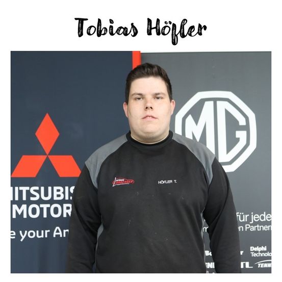 Ein Mann steht vor einem Hintergrund mit Logos und Text. Er trägt ein schwarz-graues Shirt mit roten Logos. Der Hintergrund zeigt ein Mitsubishi-Logo und den Text 'Motor'. Über ihm steht der Name 'Tobias Hofler'.