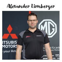 Ein Mann namens Alexander Lirnberger steht vor einer Wand mit einem Mitsubishi Motors Logo und einem MG Logo. Er trägt ein schwarz-graues Poloshirt mit dem Namen Lirnberger A. auf der Brust.