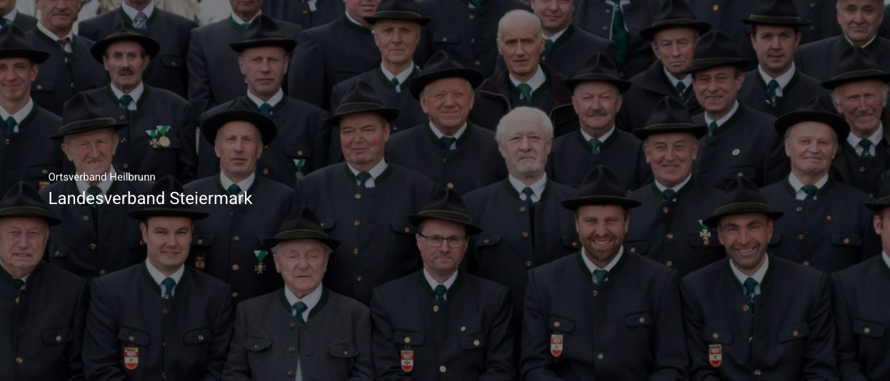Eine Gruppe von Männern in formeller Kleidung, einschließlich Hüten und Krawatten, lächelt und posiert für ein Foto. Sie sind wahrscheinlich Mitglieder einer formellen Organisation.