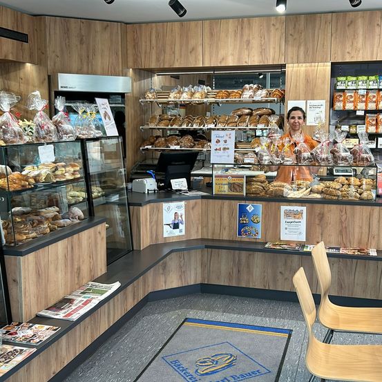 Bild enthält, Shop, Indoors, Person, Bakery, Face, Head, Chair, Furniture, Grocery Store