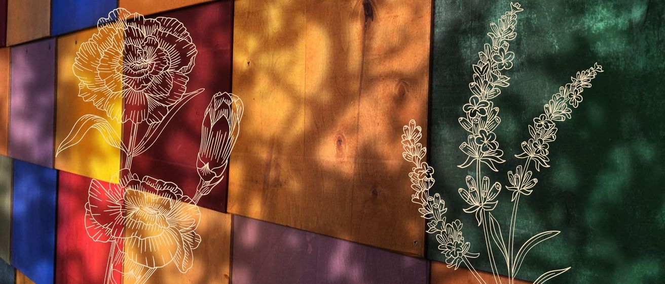Eine Holzwand mit einem braunen Mittelteil und burgunderroten und lila Seiten. Der braune Teil hat eine natürliche Holzmaserung und ein weißes Blumendesign auf der rechten Seite. Die burgunderroten und lila Teile haben weiße Blumendesigns auf ihrer linken Seite.