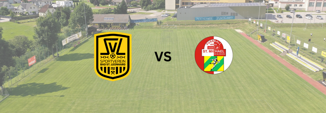 Ein Fußballfeld zeigt ein Spiel zwischen Sportverein Bad St. Leonhard und St. Michael. Das Feld ist von Bäumen und Gebäuden umgeben.