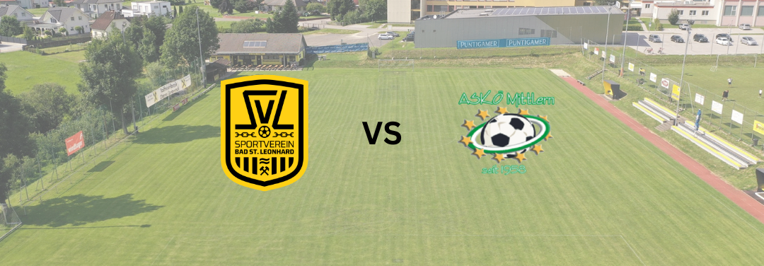 Ein Fußballfeld mit Logos zweier Teams, Sportverein Bad St. Leonhard und ASKO Mitterl, vor einer Kulisse aus Gebäuden und Bäumen.