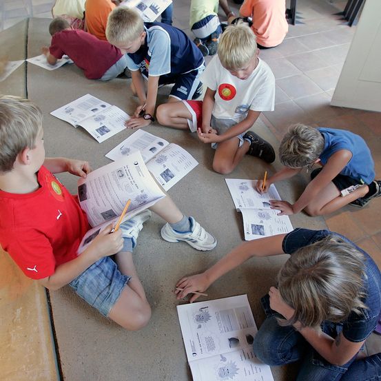 Bild enthält, Person, Boy, Child, Male, Floor, Text, Flooring, Pen, Shoe, Face