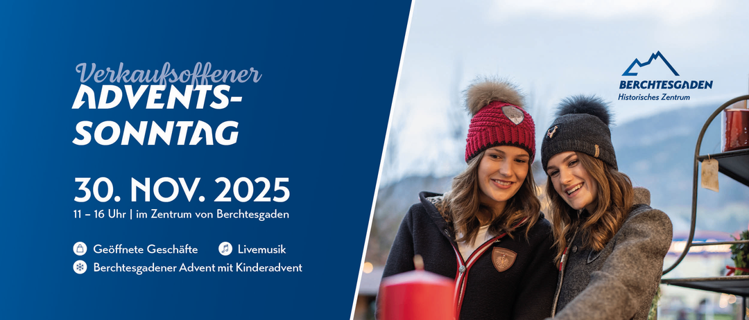 Eine Werbung für ein Winterevent im November 2025 im Zentrum von Berchtesgaden. Es zeigt zwei lächelnde Frauen mit Wintermützen, eine hält eine rote Kerze. Der Hintergrund ist verschneit.