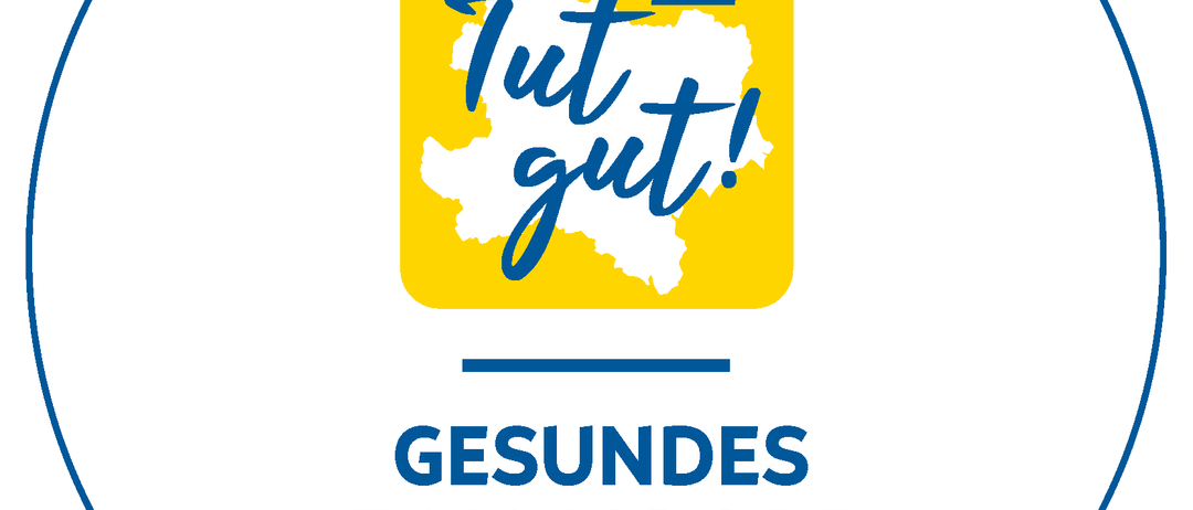 Ein gelber kreisförmiger Logo mit einer Karte einer Region im Inneren, beschriftet mit 'Tut gut!' und 'Gesundes Zillingdorf'. Die Karte ist weiß mit blauen Umrissen.