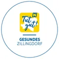 Das Logo von Gesundes Zillingdorf zeigt einen gelben Kreis mit 'Tut gut!' in Blau und dem Namen 'Zillingdorf' darunter.