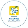 Das Logo von Gesundes Zillingdorf zeigt einen gelben Kreis mit 'Tut gut!' in Blau und dem Namen 'Zillingdorf' darunter.
