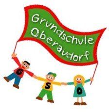 Drei Kinder, die Händchen halten, eines hält ein Banner mit dem Text 'Grundschule Oberaudorf'. Die Kinder tragen bunte Kleidung und scheinen zu feiern.
