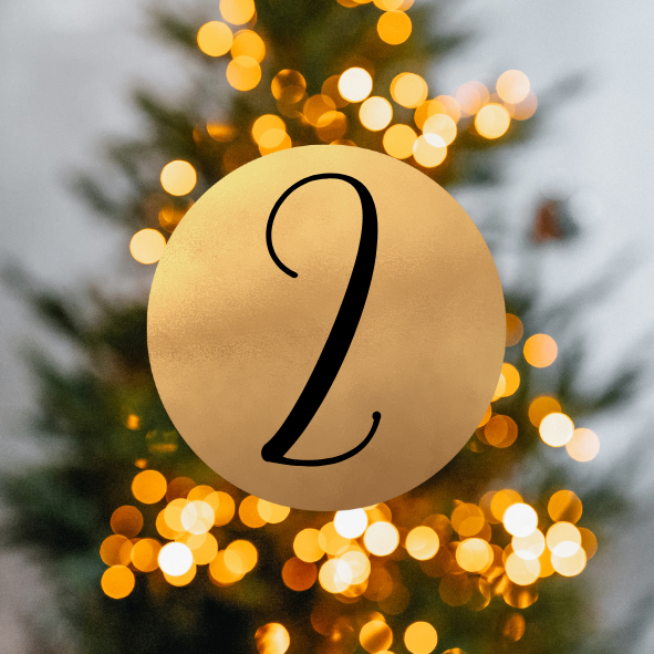 Eine goldene Kreis mit der Nummer 2 steht vor einem Weihnachtsbaum mit warmen Lichtern.