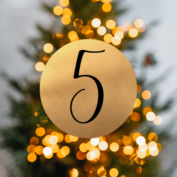 Ein goldener Kreis mit der Nummer 5 steht vor einem Weihnachtsbaum mit verschwommenen Lichtern.