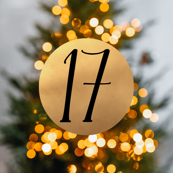 Ein goldener Kreis mit der Nummer 17 im Vordergrund und einem Weihnachtsbaum im Hintergrund. Der Baum ist mit Bokeh-Lichtern geschmückt.
