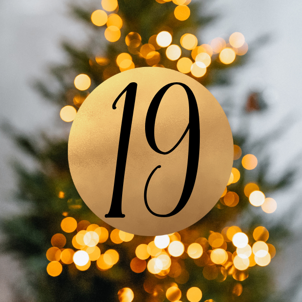 Eine goldene Kreisform mit der Nummer 19 in Schwarz, vor einem geschmückten Weihnachtsbaum mit funkelnden Lichtern.