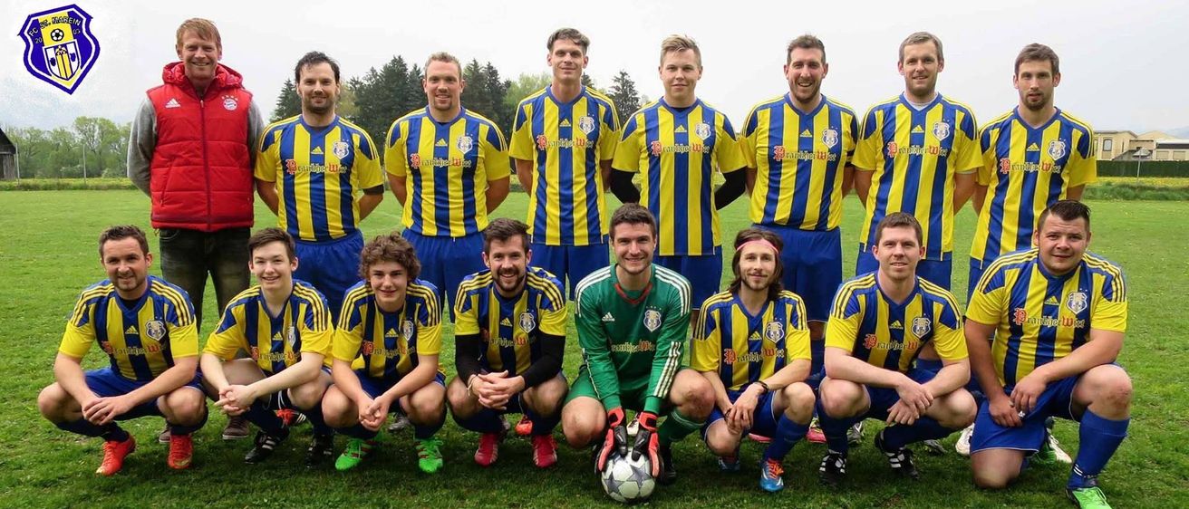 Ein Fußballteam posiert für ein Foto auf einem Rasenfeld, wobei die Spieler gelbe und blaue Uniformen tragen. Der Torwart kniet mit einem Fußball in der Mitte.
