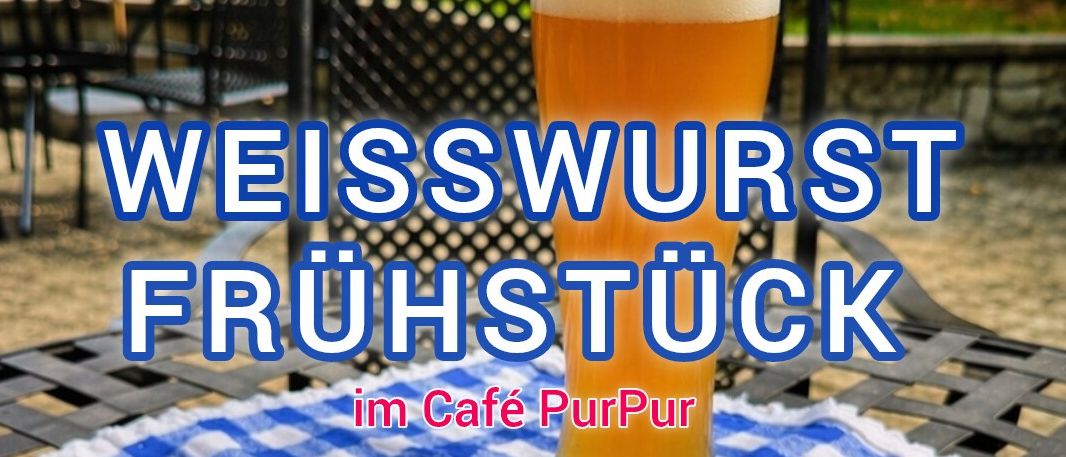 Ein Teller mit zwei Weißwürsten, einem Brötchen und einer kleinen Schüssel Senf auf einer blau-weiß karierten Tischdecke, mit einem vollen Glas Bier.